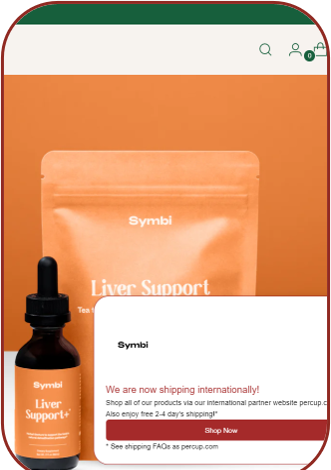 Symbi storefront with an international shipping popup reading 'We are now shipping internationally!' and a Shop Now button